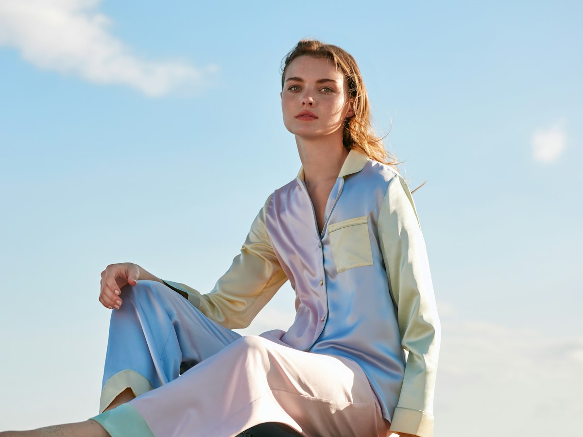Woman in pastel satin pyjamas outdoors